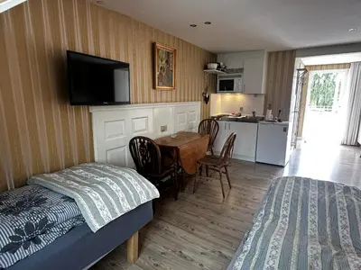 a bedroom with a bed and a table and a kitchen at Oasen in Viborg