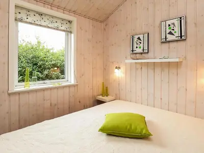 a bedroom with a bed with a green pillow on it at 8 person holiday home in Fjerritslev in Fjerritslev