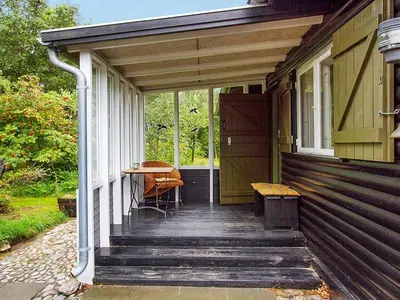a porch of a house with a bench and a table at 8 person holiday home in Roslev-By Traum in Roslev