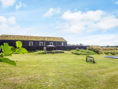 a house with a grass yard in front of it at 8 person holiday home in Saltum-By Traum in Saltum