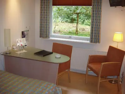 a room with a table and chairs and a window at Rold StorKro in Skorping