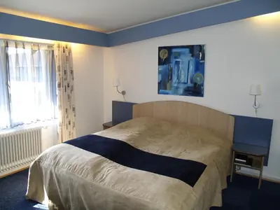a bedroom with a large bed and a window at Rold StorKro in Skorping