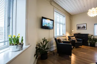 a living room with a couch and a tv on a wall at Bed & Breakfast Holstebro in Holstebro