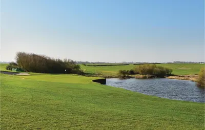 a golf course with a pond next to a green at 2 Bedroom Lovely Apartment In Lemvig in Lemvig