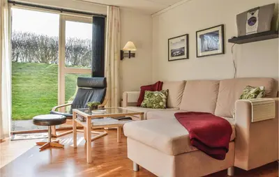 a living room with a couch and a table at 2 Bedroom Lovely Apartment In Lemvig in Lemvig