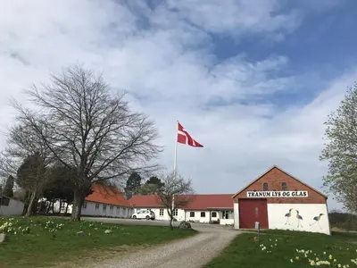 a red flag on a pole in front of a building at Tranum Lys og Glas in Brovst