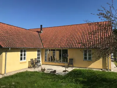 a yellow house with a red roof at Tranum Lys og Glas in Brovst
