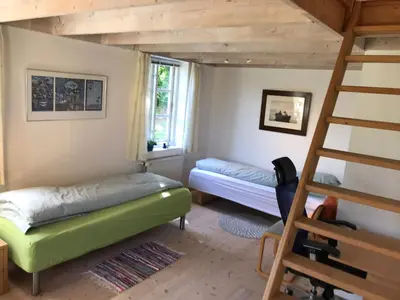 a bedroom with two bunk beds and a ladder at Tranum Lys og Glas in Brovst