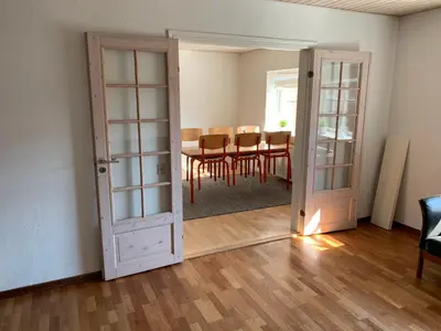 a room with a dining room table and a door at Idrætscenter Jammerbugt in Fjerritslev
