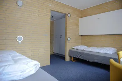 a room with two beds and a projection screen at Idrætscenter Jammerbugt in Fjerritslev