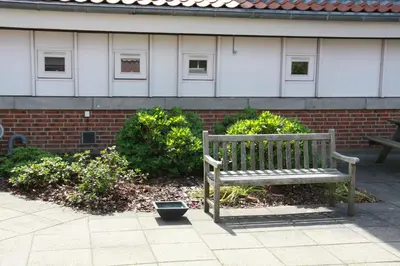 a wooden bench sitting in front of a brick building at Motel Spar 10 in Viborg
