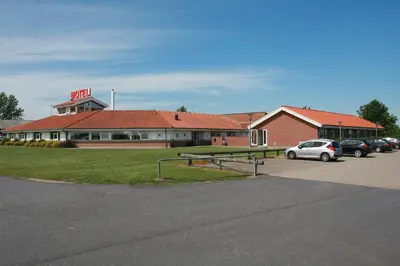 a building with a car parked in a parking lot at Motel Spar 10 in Viborg