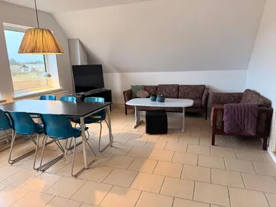 a living room with two tables and a couch at Guesthouse Hune in Blokhus