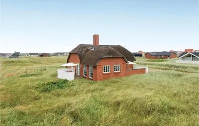 a small brick house in a field of grass at Three-Bedroom Holiday Home In Harboore in Harboør