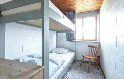 a bedroom with two bunk beds and a chair at Three-Bedroom Holiday Home In Frostrup in Frøstrup