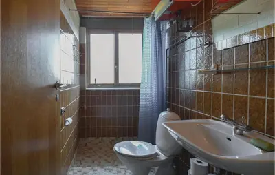 a bathroom with a toilet and a sink at Three-Bedroom Holiday Home In Frostrup in Frøstrup