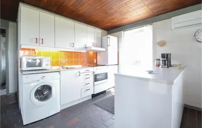 a kitchen with white cabinets and a washer and dryer at Three-Bedroom Holiday Home In Frostrup in Frøstrup