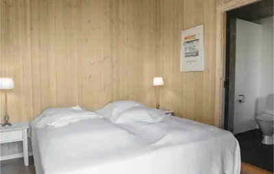 a bedroom with a white bed and a toilet at Five-Bedroom Holiday Home In Lokken in Løkken