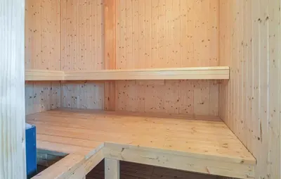 a wooden sauna with a wooden bench in it at Five-Bedroom Holiday Home In Lokken in Løkken