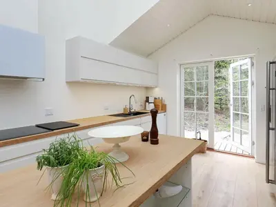 a kitchen with white cabinets and a wooden counter top at 6 person holiday home in Blokhus-By Traum in Blokhus