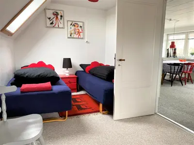 a room with two beds and a table with a table at Apartment med udsigt over Nordmors in Sejerslev