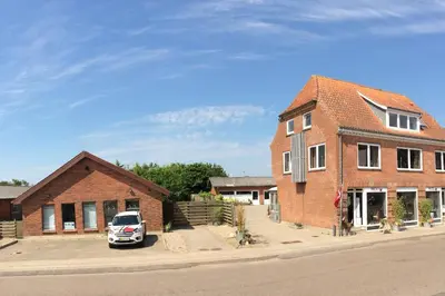 a car parked in front of a brick house at Hyggeligt byhus ved glasværkstedet på Nordmors in Sejerslev