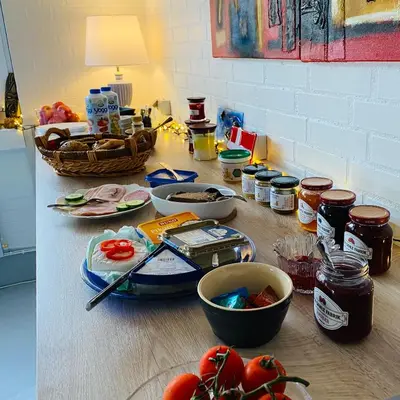 a kitchen counter with food on a table at Hyggeligt byhus ved glasværkstedet på Nordmors in Sejerslev