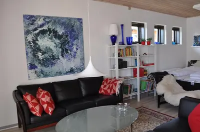 a living room with a couch and a table at Hyggeligt byhus ved glasværkstedet på Nordmors in Sejerslev