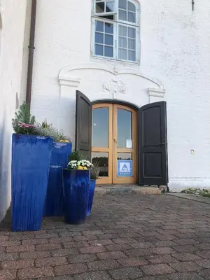 two blue containers sitting in front of a building at Vitskøl Kloster in Ranum