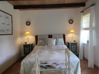a bedroom with a bed with a chair with books on it at Rosengave in Alsted