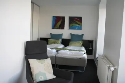 a room with two beds and a chair in it at Seaside Hotel Thyborøn in Thyborøn