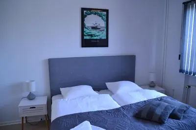 a bedroom with two beds and a picture on the wall at Thyborøn Hotel in Thyborøn