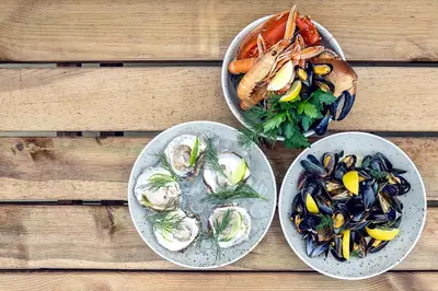 three plates of food on a wooden table at Thyborøn Hotel in Thyborøn