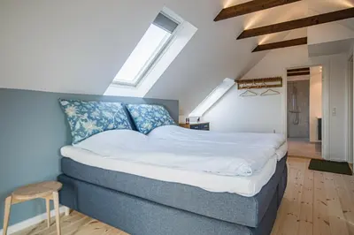 a bedroom with a large bed in a attic at Hotel Højgaarden in Slettestrand