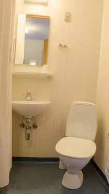 a bathroom with a white toilet and a sink at Hotel Højgaarden in Slettestrand