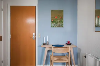 a room with a table and two chairs next to a door at Hotel Højgaarden in Slettestrand