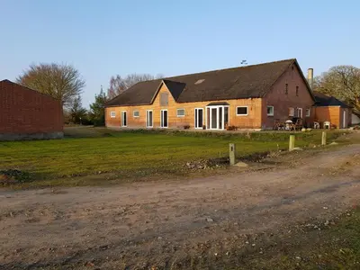 a large brick house on the side of a dirt road at Kyndestoft Bed & Breakfast in Holstebro