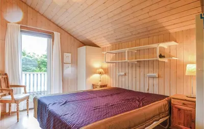a bedroom with a purple bed and a window at Four-Bedroom Holiday Home In Lokken in Løkken