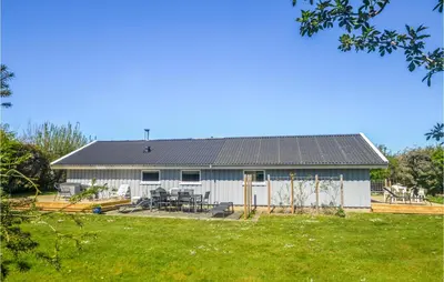 a house with a solar roof and a yard at Four-Bedroom Holiday Home In Lokken in Løkken