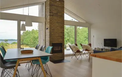 a living room with a table and chairs and a fireplace at Three-Bedroom Holiday Home In Skals in Skals
