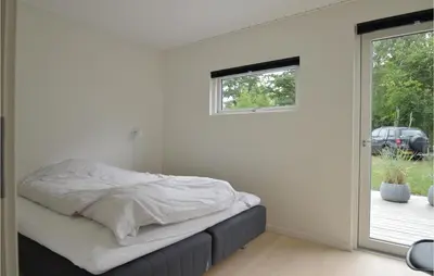 a bedroom with a bed with white sheets and a window at Three-Bedroom Holiday Home In Skals in Skals