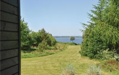 a driveway leading to a lake from a house at Three-Bedroom Holiday Home In Skals in Skals