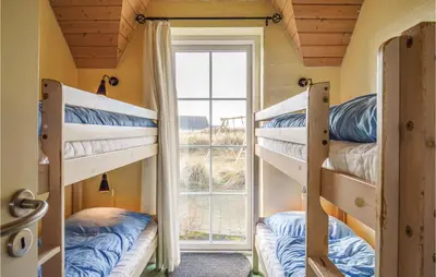 two bunk beds in a room with a window at Nice Home In Harboøre With Kitchen in Harboør