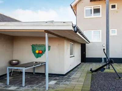 awning on the side of a house with a bench on the patio at 4 person holiday home in Thyborøn-By Traum in Thyborøn