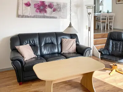 a black leather couch in a living room with a table at 4 person holiday home in Thyborøn-By Traum in Thyborøn