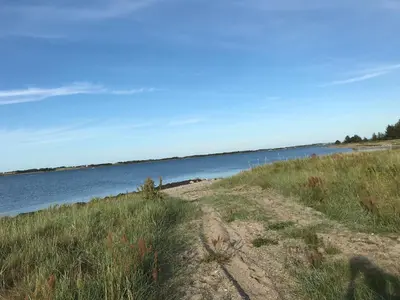 a dirt road next to a body of water at Summer cottage in Nøreng