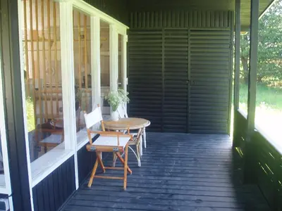 a patio with a table and chairs on a porch at Summer cottage in Nøreng