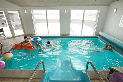 a group of people playing in a swimming pool at Luksus-poolhus B5 in Harboør
