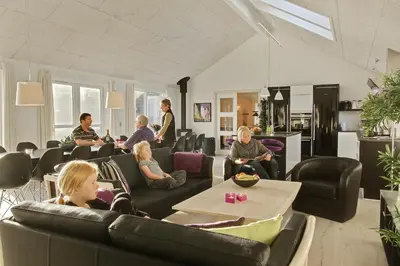 a group of people sitting in a living room at Luksus-poolhus L21 in Harboør
