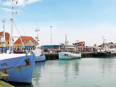 a group of boats docked in a harbor with houses at 6 person holiday home in Thyborøn in Thyborøn